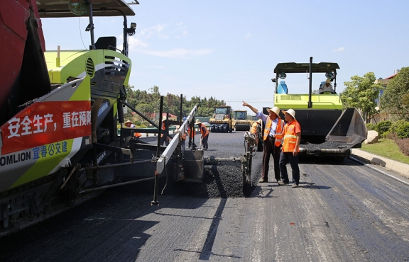 攤鋪機(jī)、壓路機(jī)等設(shè)備緊張有序運(yùn)行，高達(dá)170℃的瀝青混合料炙烤著公路人